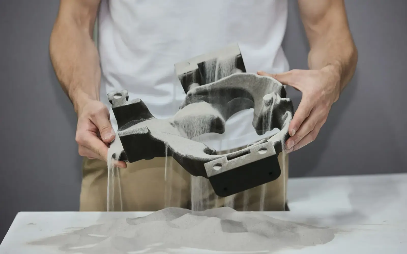 Специалист держит крупную песчаную форму, изготовленную методом Binder Jetting