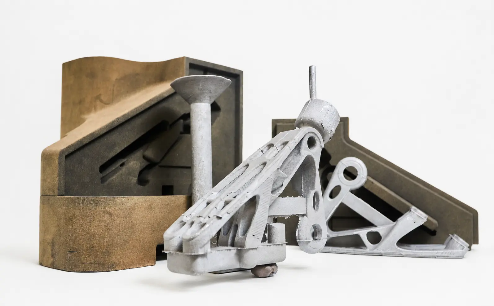 3D-printed sand moulds alongside the resulting metal castings
